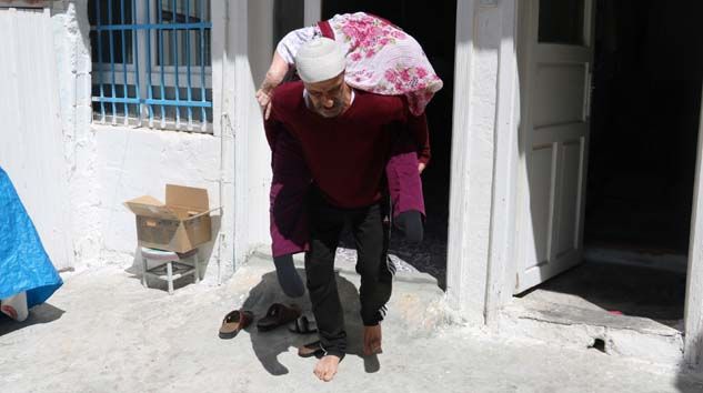 Yatalak annesini sırtına alıp sokakta gezdirdi