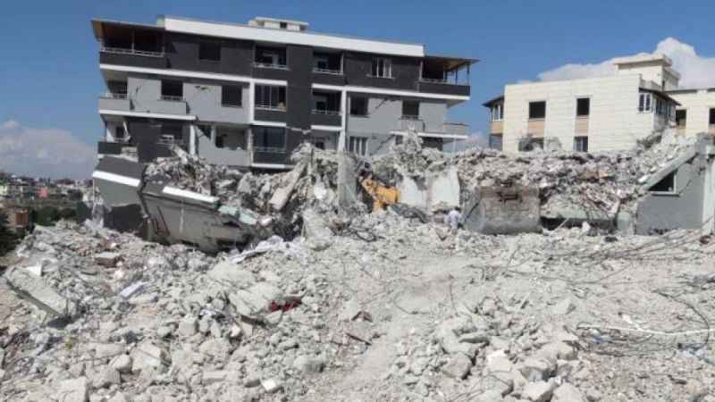 Ağır hasarlı binayı yıkan kepçe operatörü enkaz altında kaldı