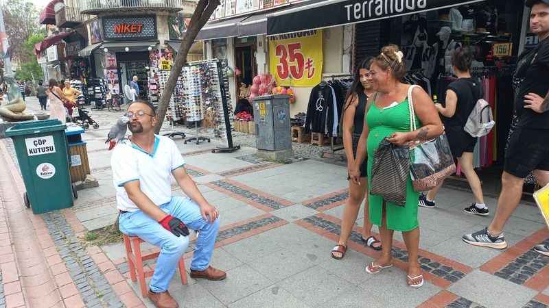 Hayat arkadaşı papağanı ile sokaklarda geziyor Hayat arkadaşı papağanı ile sokaklarda geziyor