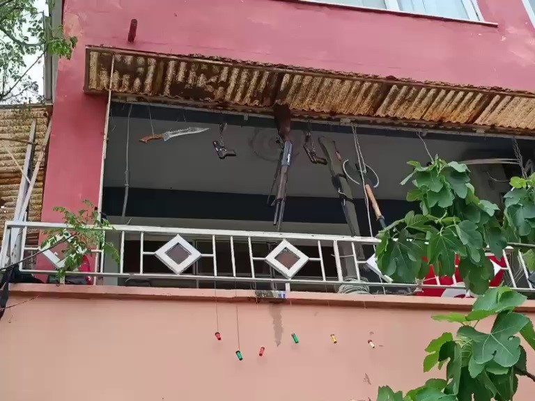 Balkonda silah, balta ve kılıç sergileyen şahıs hayrete düşürdü
