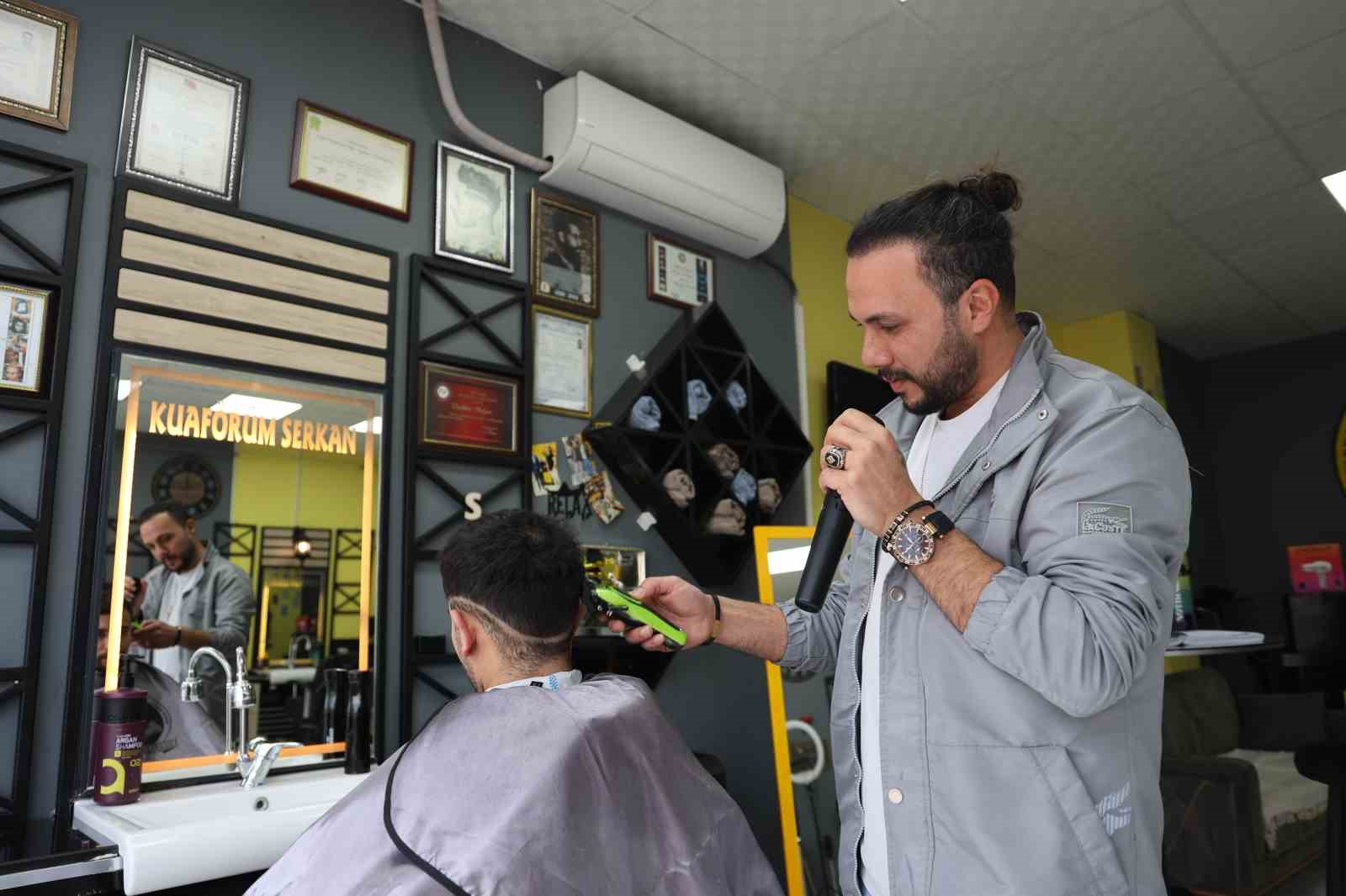 Bir elinde makas diğer elinde mikrofon
