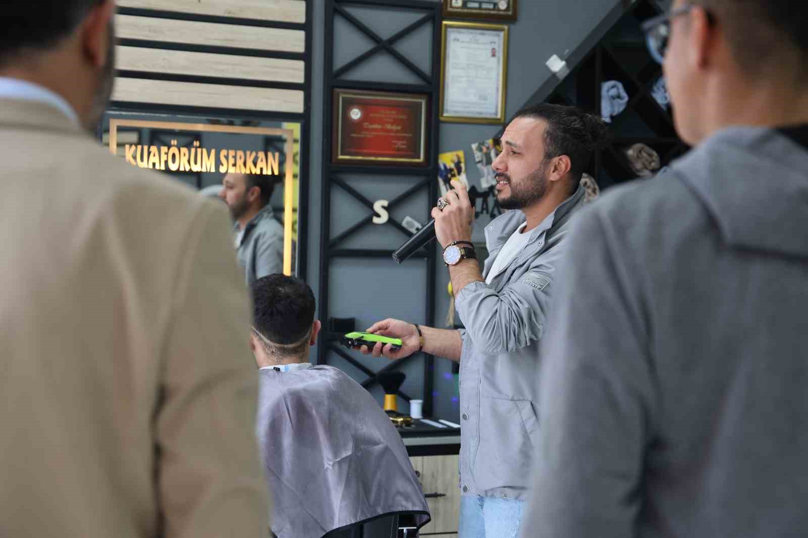 Bir elinde makas diğer elinde mikrofon
