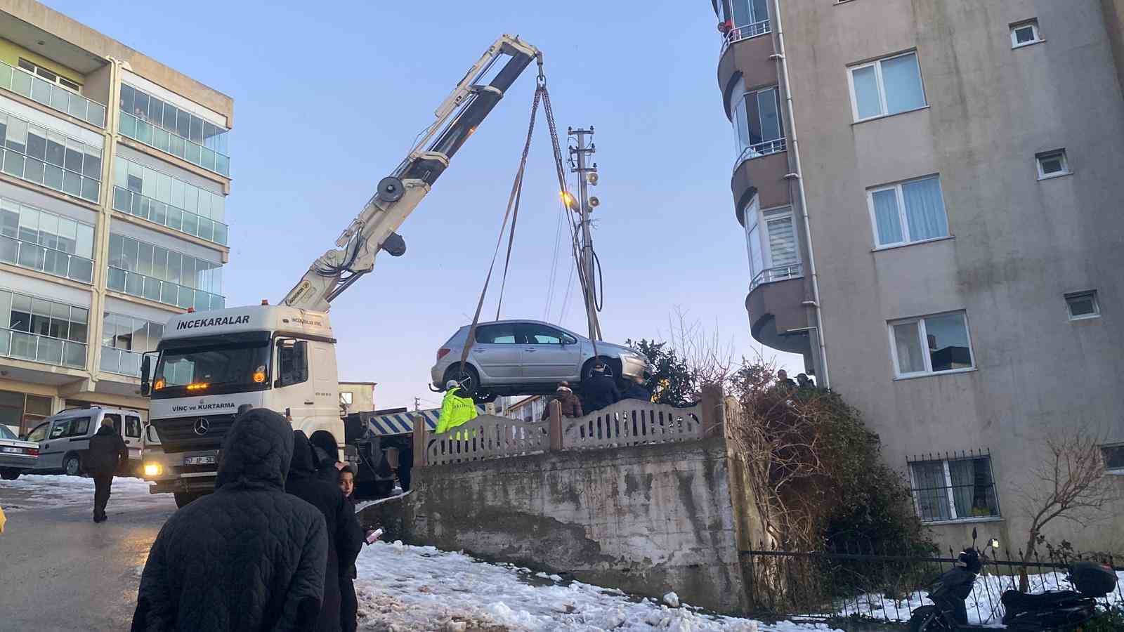 Buzlanan yolda kayan otomobil apartmanın bahçesine düştü

