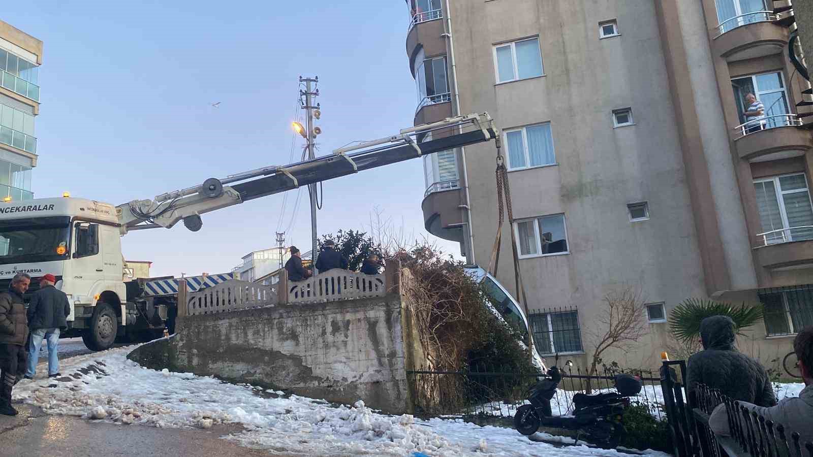 Buzlanan yolda kayan otomobil apartmanın bahçesine düştü
