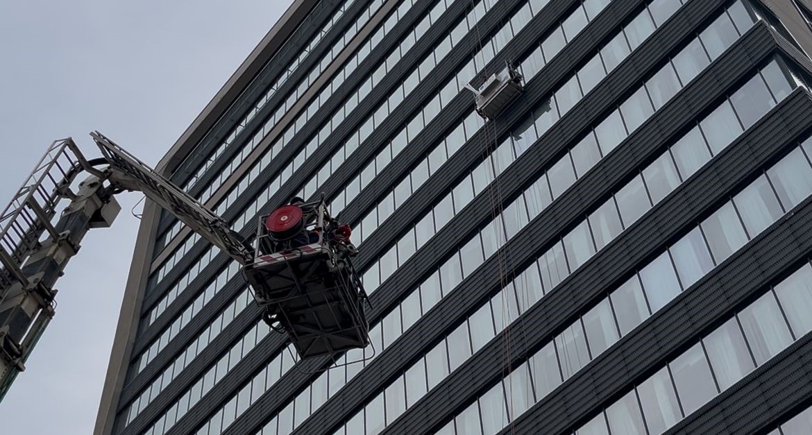 Dış cephede cam silerken asansör sistemi arıza yapınca mahsur kaldılar: İtfaiyenin müdahalesiyle kurtarıldılar
