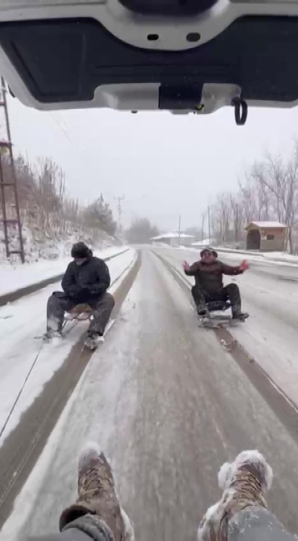 Kar yağışını aracın arkasına bağlanan kızaklarla kutladılar

