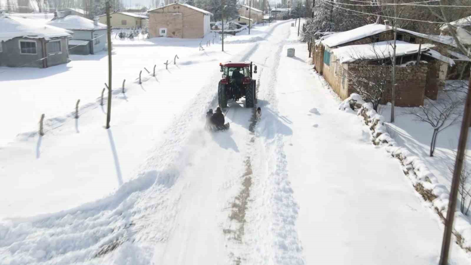 Kar yağışını fırsata çevirdiler, traktörün arkasında kayarak eğlendiler
