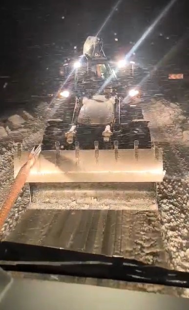 Karlı yolda mahsur kalan tır, iş makinesiyle kurtarıldı
