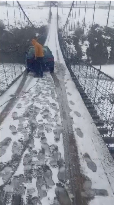 Kars’ta asma köprüde korku dolu anlar: Otomobil buzda kayarak asılı kaldı
