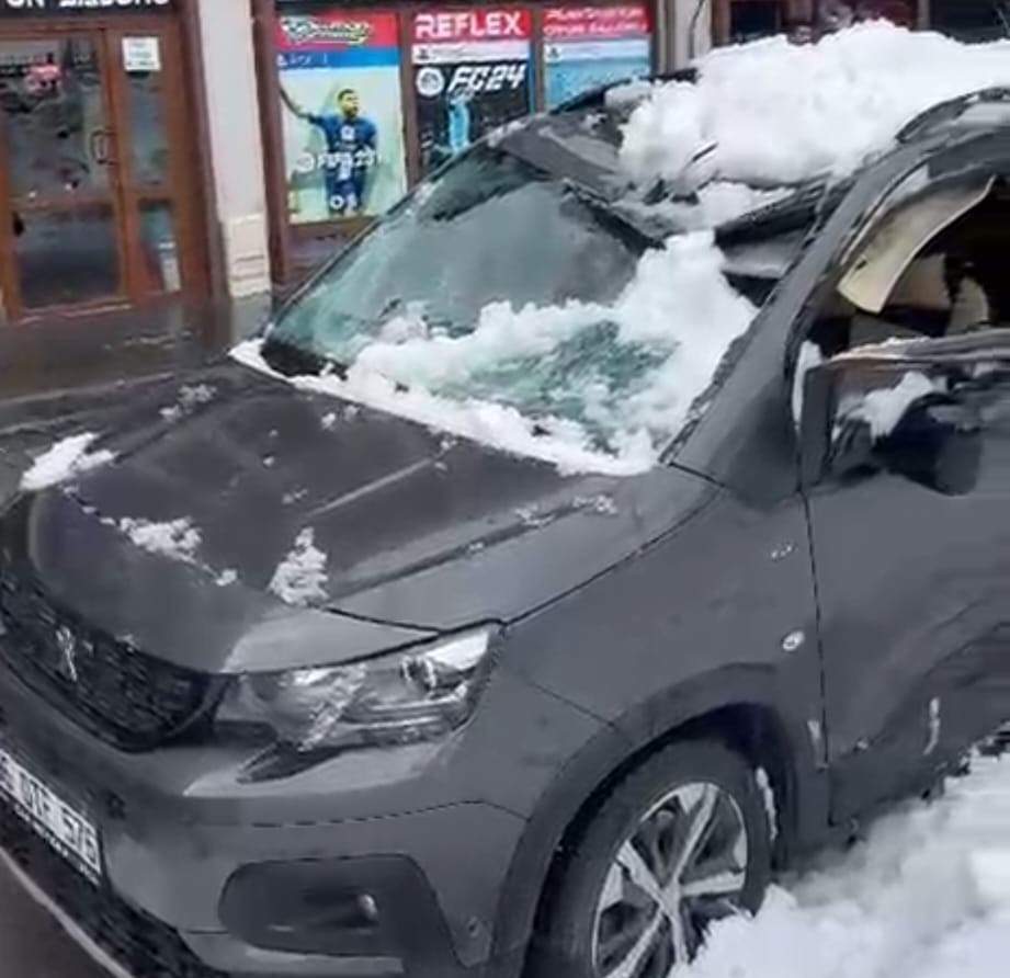 Park halindeki aracın üzerine çatıdan kar kütlesi düştü
