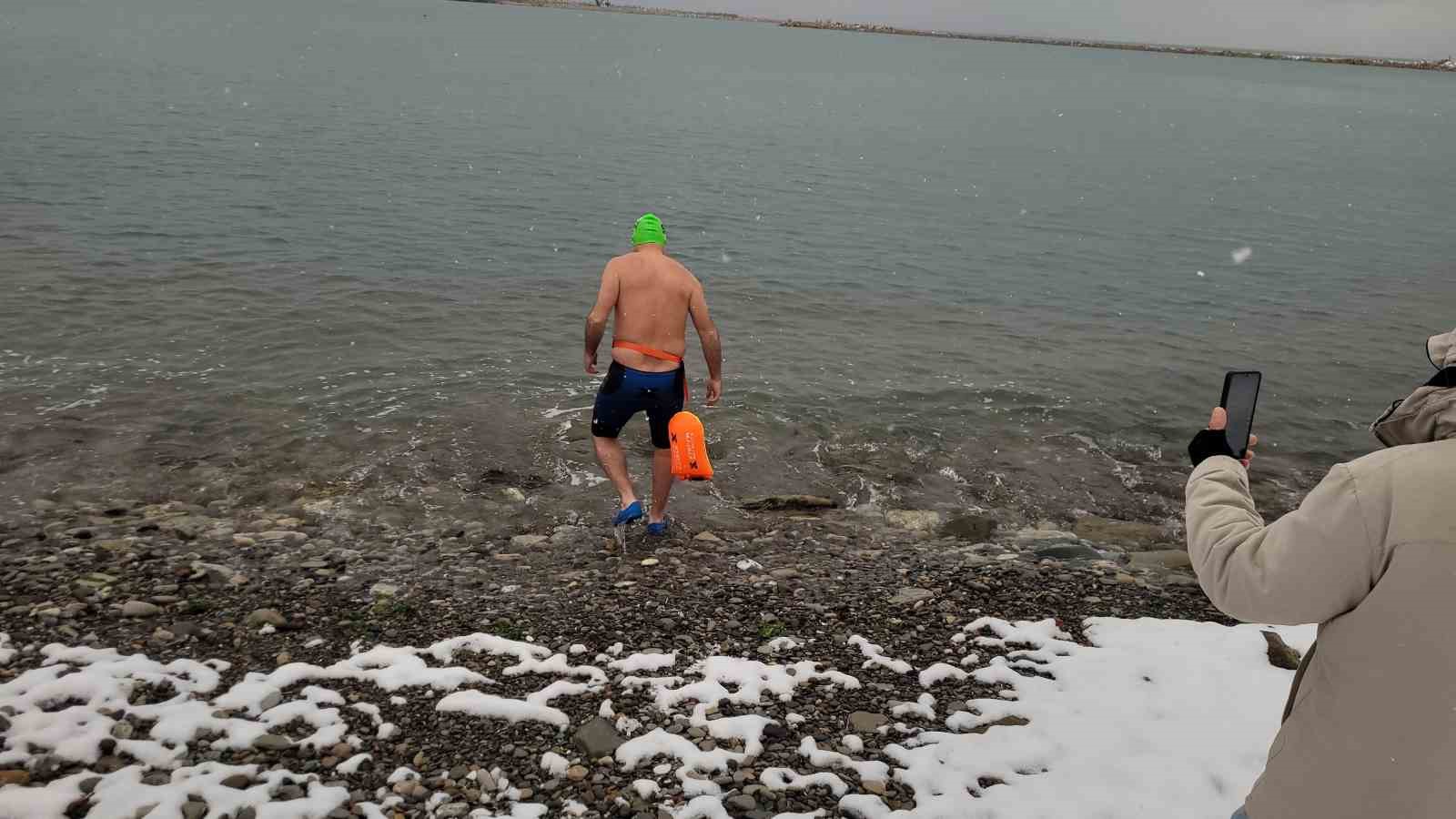 Soğuğa aldırış etmedi, kar altında denizde yüzdü
