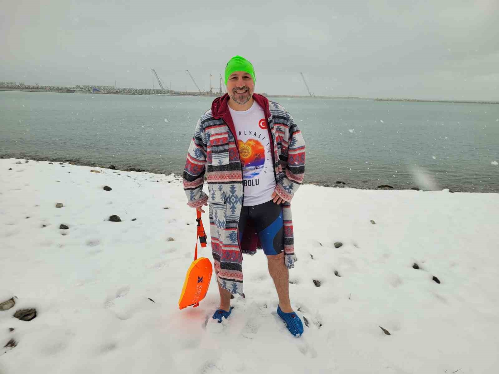 Soğuğa aldırış etmedi, kar altında denizde yüzdü
