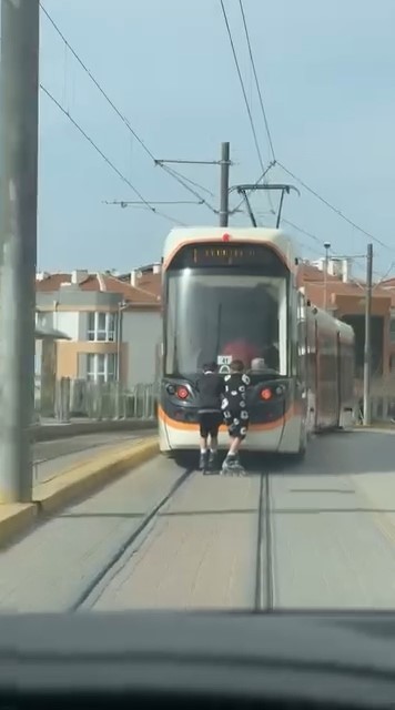 Tramvayın arkasına tutunan patenli çocukların tehlikeli yolculuğu
