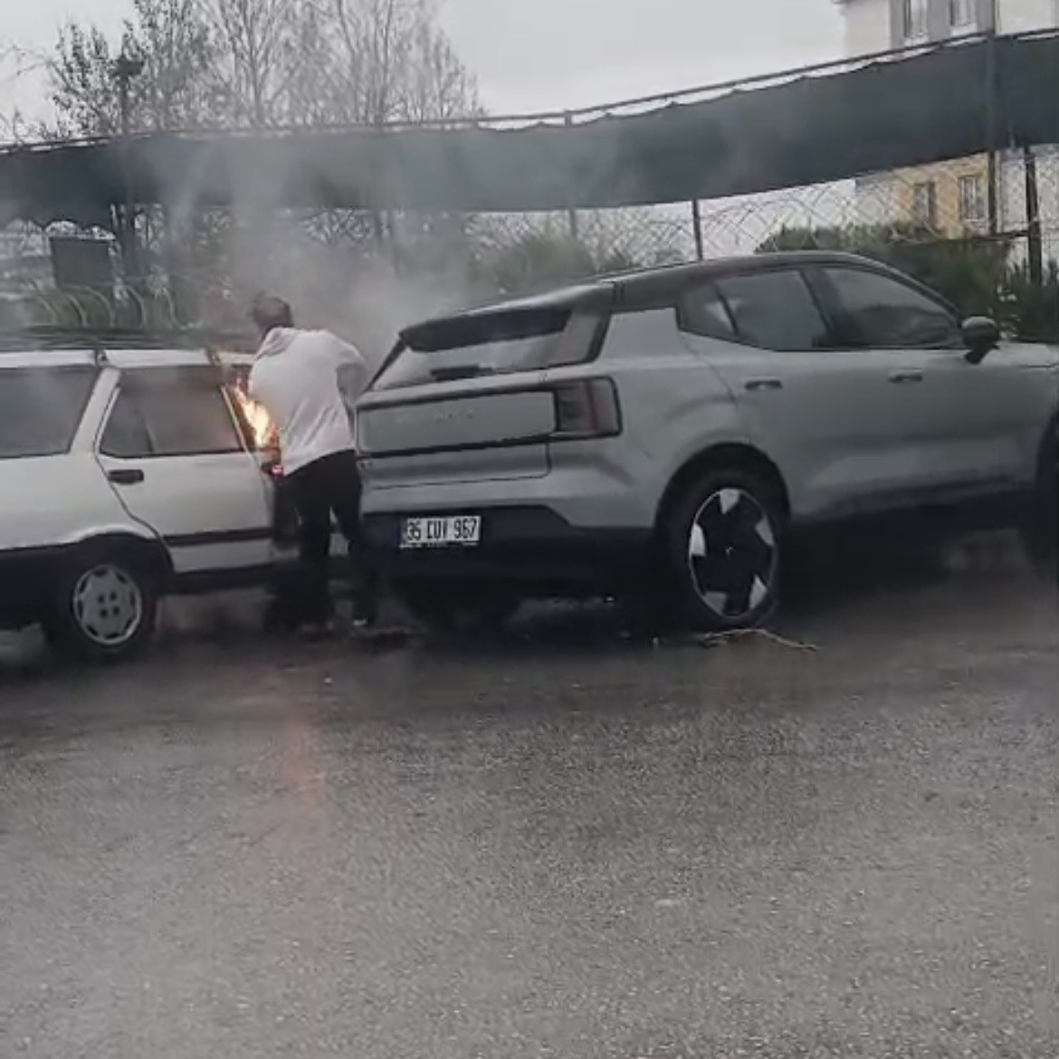 Yanan otomobile yol kenarındaki su birikintisinden doldurduğu kovayla müdahale etti
