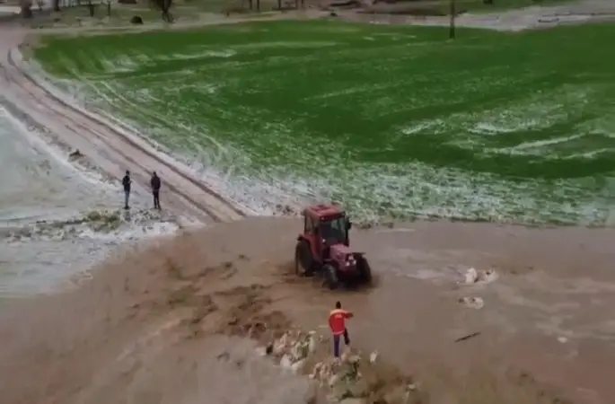 Sağanak taşkına neden oldu, tarlada mahsur kalan şahıs traktörle kurtarıldı
